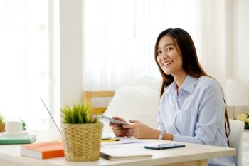 Young asian woman working with digital tablet at home office with happy emotion, working from home, small business, office casual lifestyle concept