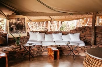 JUN 20, 2011 Tanzania - African Luxury Safari lodge living room with white cusions and Boho tribal furniture in Savanna forest of Serengeti Grumeti wildlife Reserve.