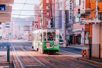 DEC 2, 2018 Hakodate, JAPAN - Hakodate city tram vintage streetcar approaching station near JR train station. The Tram well-established network throughout the city, and are main transportation for sightseeing.