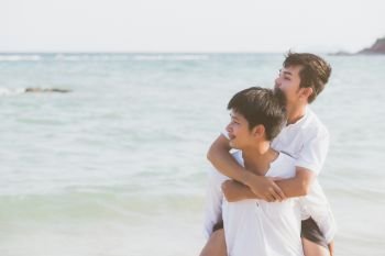 Homosexual portrait young asian couple riding the neck together with enjoy and fun on beach in summer, asia gay cheerful going sea for leisure with romantic and happy vacation at sea, LGBT with legal.