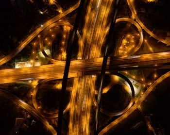 Aerial view of cars driving on highway junctions. Bridge roads shape number 8 or infinity sign in connection of architecture concept. Top view. Urban city, Taipei at night, Taiwan.