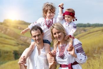 Ukrainian family at the  outdoor. dad, mom and two daughters in traditional national clothes vyshivanka
