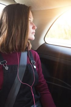 girl teenager in the car wearing a seat belt. road safety
