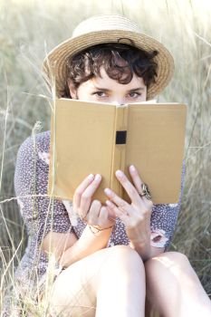 retro style. girl in a hat sits and reads a book
