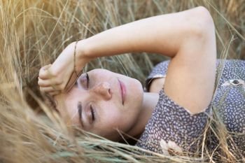 happy girl lies in dry grass. emotions and mood
