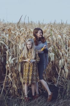 family and life outside the city. mom and daughter in a corn field.
