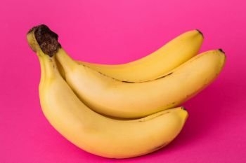 delicious ripe bananas on a pink background
