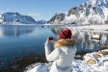 girl travels around lofoten islands and takes pictures on camera. beautiful Norwegian landscape. Norway
