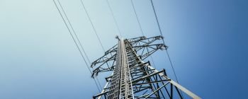 Picture of an electrical tower or pylon, blue sky in the background. Power grid or smart grid. 