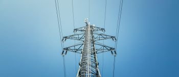 Picture of an electrical tower or pylon, blue sky in the background. Power grid or smart grid. 