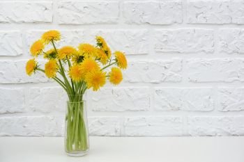 Bouquet of yellow dandelion in vase on table background white brick wall Copy space Minimal style. Template for postcard, text, design Concept Women’s day, Mothers Day, Hello summer or Hello spring.. Bouquet of yellow dandelion in vase on table background white brick wall Copy space Minimal style. Template for postcard, text, design Concept Women’s day, Mothers Day, Hello summer or Hello spring