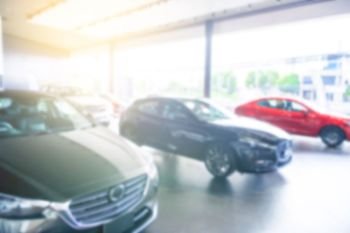 Blurred background of cars for sale in showroom. Automotive car and business transportation concept. Abstract background.