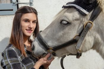 portrait of a beautiful young woman rider with the white horse
