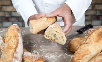 a baker cutting traditional bread french baguettes