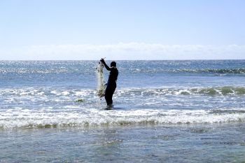 African fisherman in shallow water with his fishing net