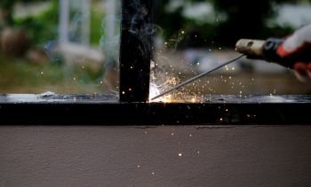 Welder Technician are welding steel with sparks flying