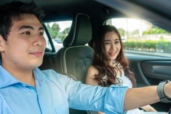 Asian Couple are driving in a car for test drive before buy new car,