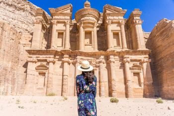 Asian young woman in colorful dress and hat enjoying at The Monastery, Petra’s largest monument, UNESCO World Heritage Site, Jordan.