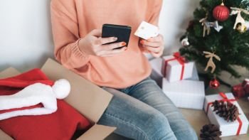 Young woman holding credit card and doing shopping online. New year, Christmas gift shopping. 