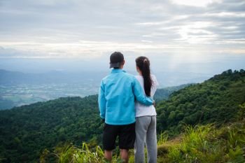 rear of couple love feel happy woman stand on top mountain looking view with mist and cloud 