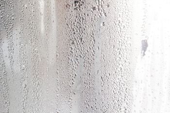 Water rain drops or steam shower on window glass.