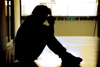 sad silhouette of man in depression sitting with his head down,dramatic concept.