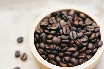 Roasted coffee beans on wooden bowl