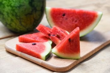 Fresh watermelon slice on wooden cutting board summer fruit 