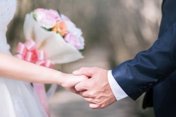 Loving Young love married couple holding hands and stand together in ceremony wedding day marry scene. Young love couple be hand in hand pinky promise or pinky swear.