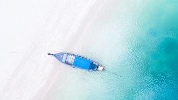 Aerial view of long tail boat is float on the emerald sea at Ao Nang Beach, Krabi, Thailand.