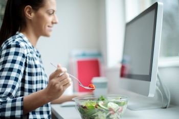 Female Worker In Office Having Healthy Salad Lunch At Desk