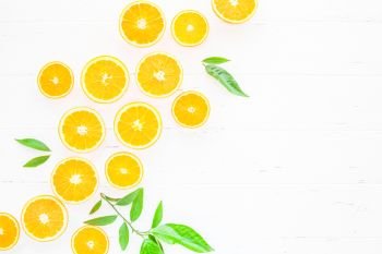 Creative scandinavian style flat lay top view of fresh orange fruit slices on white wooden table background with copy space. Minimal summer fresh citrus pattern for blog or recipe book