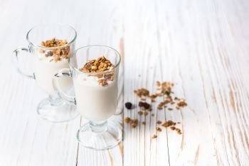 Crispy muesli in a glass with fresh yogurt, morning Breakfast, light snacks. Breakfast cereals isolated on white background, selective focus, top view.. Crispy muesli in a glass with fresh yogurt, morning Breakfast, light snacks. Breakfast cereals isolated on white background, selective focus, top view