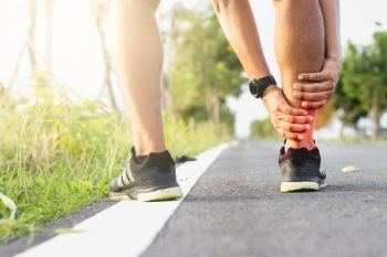 Men sit and run, are experiencing ankle pain while exercising.