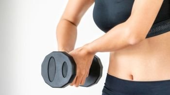 Sporty woman workout with dumbbell on clear background. Healthy lifestyle and exercising.