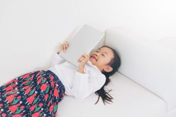 Little happy kid on white background with tablet computer. Childhood lifestyle.