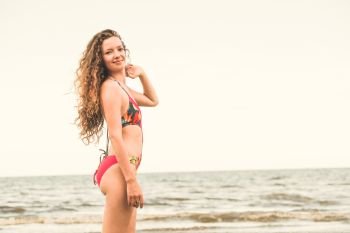 Happy young woman wearing swimsuit having good time at tropical beach in summer for holiday travel vacation.. Happy young woman at beach in summer vacation.