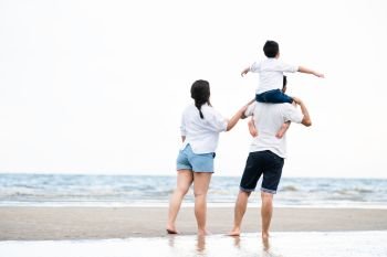 Happy family of father, mother and son goes vacation on a tropical sand beach in summer.. Happy family goes vacation on the beach in summer.