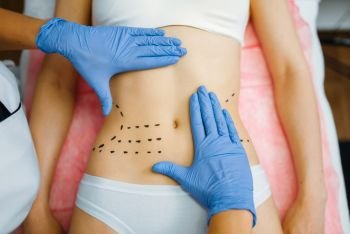 Cosmetician’s hands on female patient abdomen, botox therapy preparation. Rejuvenation procedure in beautician salon. Cosmetic surgery against wrinkles and aging