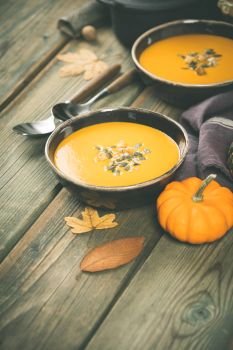 Pumpkin soup on wooden table, space for text. Pumpkin soup on wooden table, cozy food concept