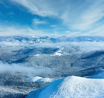 Winter mountain landscape with low-hanging clouds. View from the mount top  (Carpathian, Ukraine).