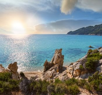 Sunset summer sandy beach and rocky coast near Platanitsi Beach, Sithonia Peninsula, Chalcidice, Greece.