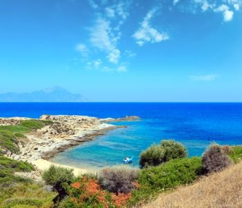 Summer stony sea coast landscape with Athos mount view in far. Halkidiki, Sithonia, Greece.