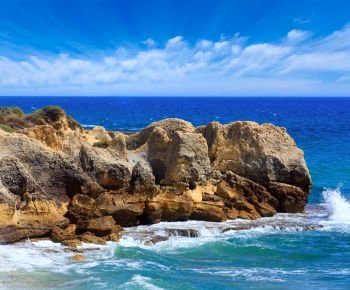Summer Atlantic rocky coast view with beautiful sky (Albufeira outskirts, Algarve, Portugal).