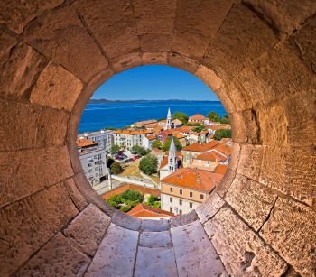 Colorful city of Zadar rooftops and towers view through stone window, Dalmatia, Croatia