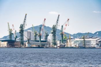Hoisting cranes in the industrial zone of the Port in Kobe Hyogo Kansai Japan using for import export shipping and global business background 
