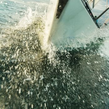 Yachting on sail boat bow stern shot splashing sea water. Sporty transportation conept.. Yachting on sail boat bow stern shot splashing water