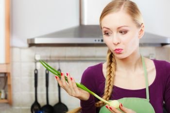 Woman in kitchen holding green fresh chive with onion. Young housewife cooking. Healthy eating, vegetarian food, dieting and people concept.. Woman in kitchen holds green fresh chive