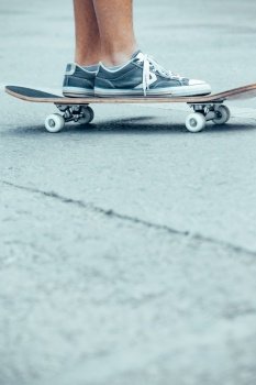 Conceptual photo of active sportive teens. Boy on a skateboard riding on the street. The activity of teenage years. Copy space for text.. Teen boy on the skateboard