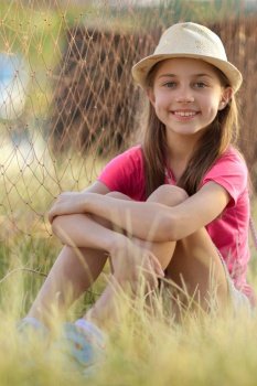 Closeup portrait of a nice girl having fun outdoors. Pretty child sitting on the field. With pleasure spending weekend in countryside. Summer vacation. Pretty nice little girl outdoors.